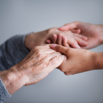 Mãos jovens segurando com carinho mãos enrugadas de uma pessoa idosa, transmitindo apoio e cuidado afetivo.
