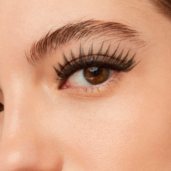 Close-up de um olho feminino com cílios alongados e curvados, mostrando o resultado de uma extensão profissional de cílios.